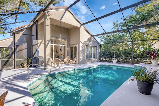 view of swimming pool with a lanai, a patio area, and ceiling fan