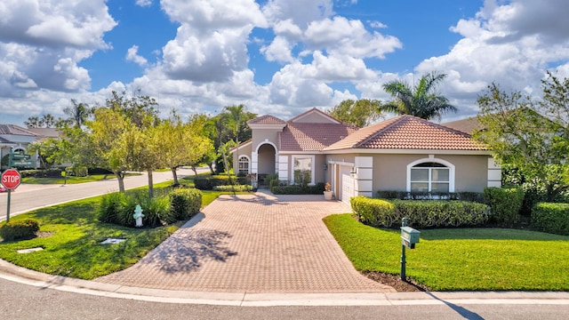 mediterranean / spanish home with a garage and a front yard