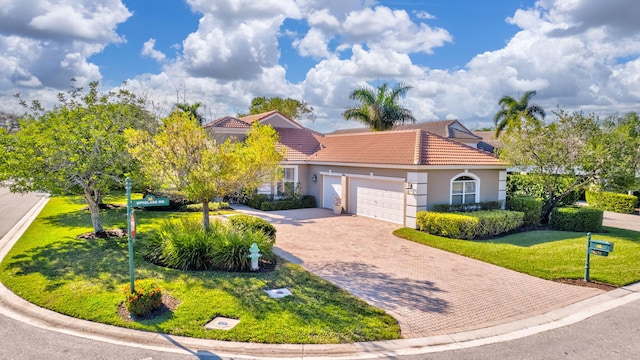 mediterranean / spanish home with a garage and a front lawn