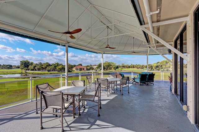 sunroom featuring a water view and ceiling fan