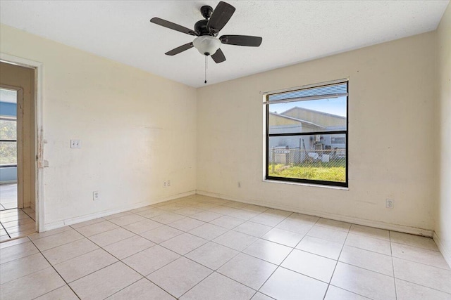 tiled spare room featuring a textured ceiling, plenty of natural light, and ceiling fan