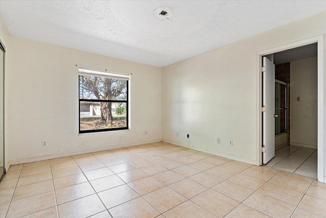 unfurnished bedroom with light tile patterned floors and a textured ceiling