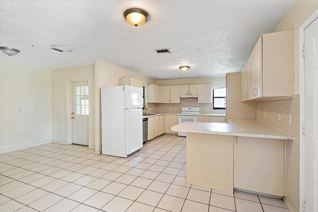 kitchen with light tile patterned flooring, sink, kitchen peninsula, white appliances, and decorative backsplash