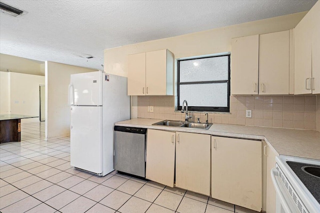 kitchen with sink, light tile patterned floors, white appliances, and decorative backsplash