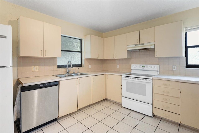 kitchen featuring cream cabinets, sink, light tile patterned floors, and white appliances