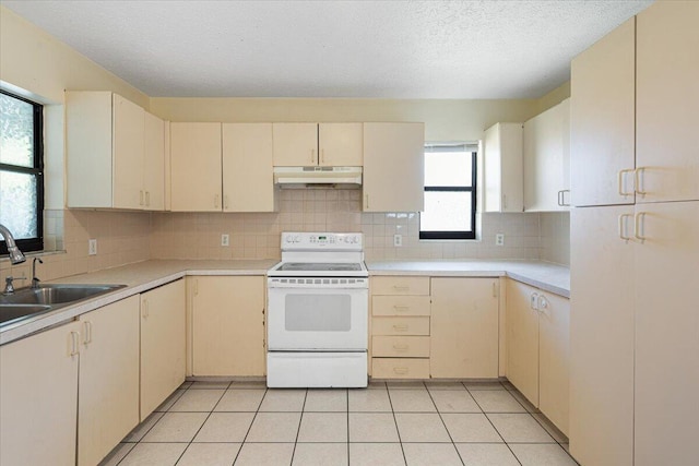 kitchen featuring cream cabinets, sink, light tile patterned floors, and white range with electric stovetop