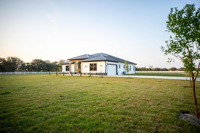 view of front of home with a garage and a yard