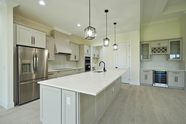 18202 Bridle Way, Fort Pierce, FL 34987 - kitchen featuring appliances with stainless steel finishes, wine cooler, light wood-style flooring, recessed lighting, and a large island with sink
