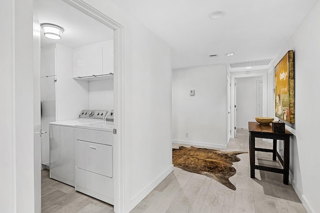 laundry area with cabinets and washing machine and clothes dryer