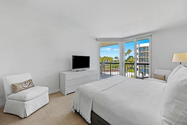 bedroom featuring access to outside, light colored carpet, and a wall of windows