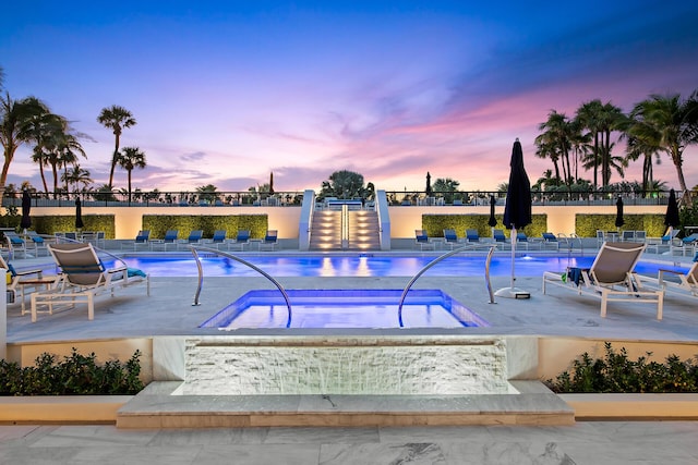 pool at dusk featuring a patio