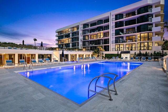 pool at dusk featuring a patio area