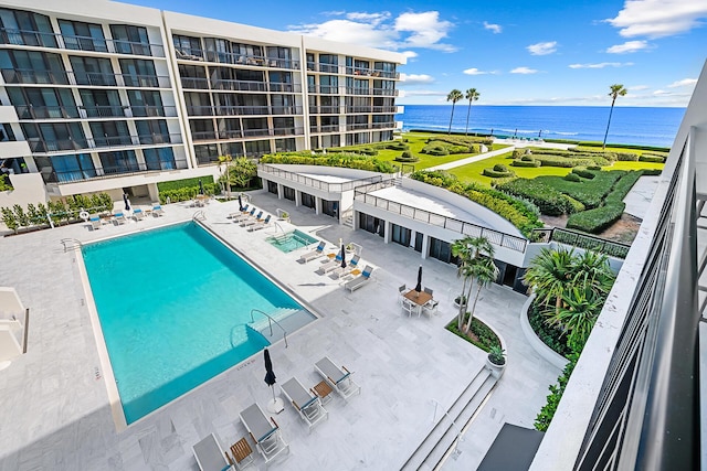 view of pool with a water view and a patio area