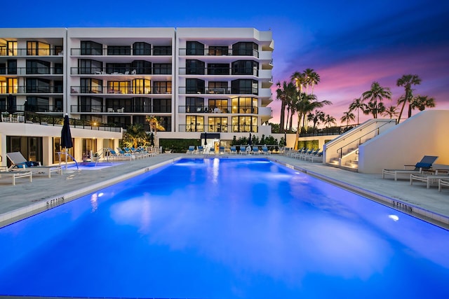 pool at dusk with a patio area