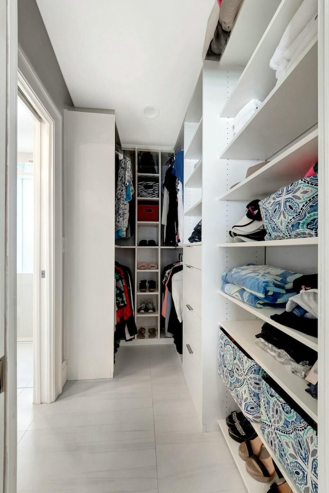 walk in closet with light tile patterned floors