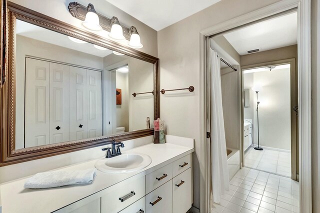 full bathroom featuring tile patterned flooring, vanity, shower / tub combo with curtain, and toilet