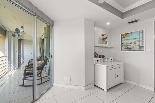 interior space with crown molding and light tile patterned floors