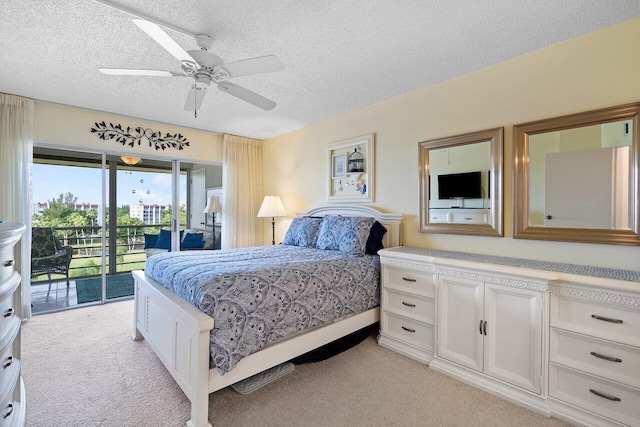 bedroom featuring light carpet, access to exterior, a textured ceiling, and ceiling fan