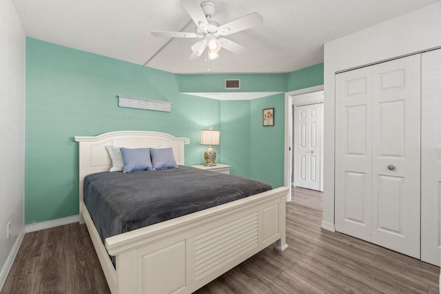 bedroom featuring wood finished floors, visible vents, a closet, and baseboards