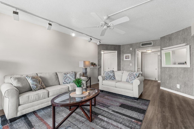 living room featuring ceiling fan, a textured ceiling, and dark hardwood / wood-style flooring