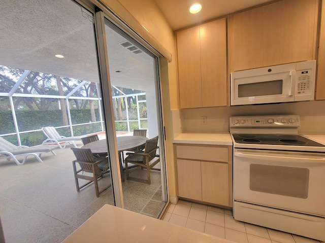 kitchen featuring light brown cabinets, light tile patterned floors, and white appliances