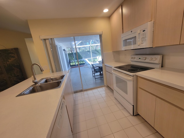 kitchen with light tile patterned flooring, sink, light brown cabinets, and white appliances