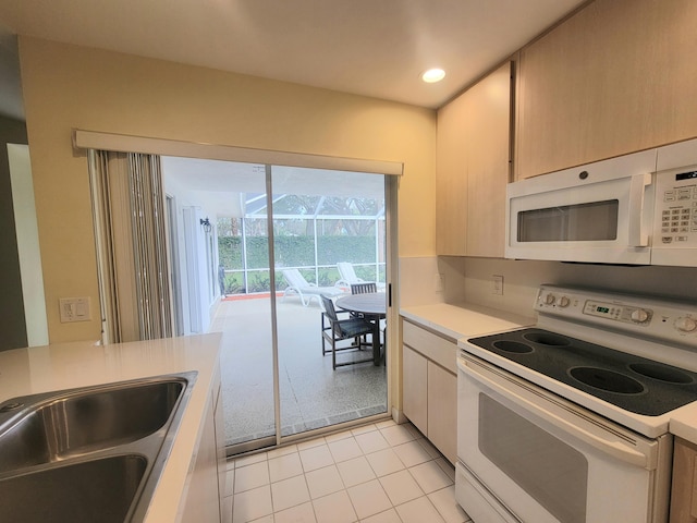 kitchen with sink, white appliances, and light tile patterned flooring