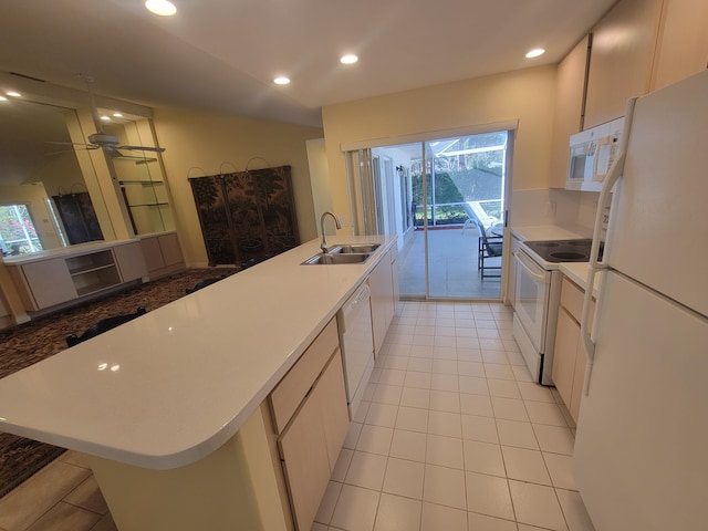 kitchen featuring sink, light tile patterned floors, ceiling fan, a center island with sink, and white appliances