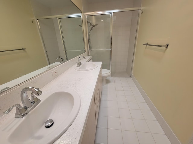 bathroom with vanity, toilet, tile patterned flooring, and a shower with door