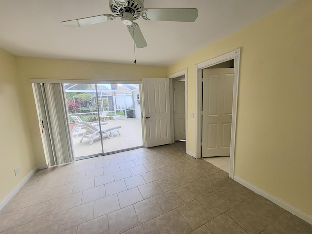 tiled spare room featuring ceiling fan