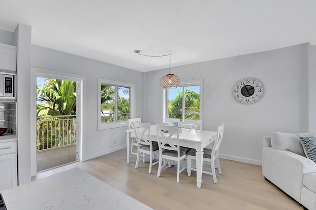 dining room featuring light wood finished floors and baseboards