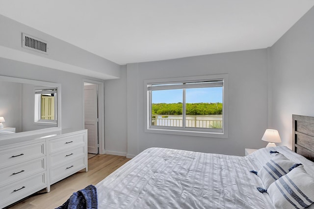 bedroom featuring light wood-type flooring, baseboards, and visible vents