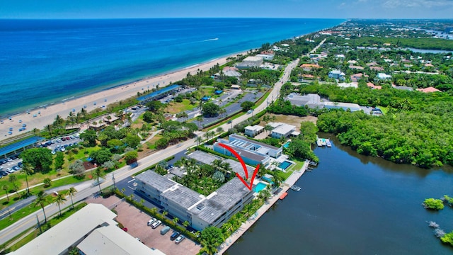 birds eye view of property featuring a water view and a beach view