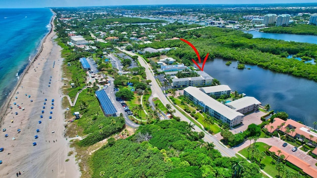 birds eye view of property featuring a water view and a beach view