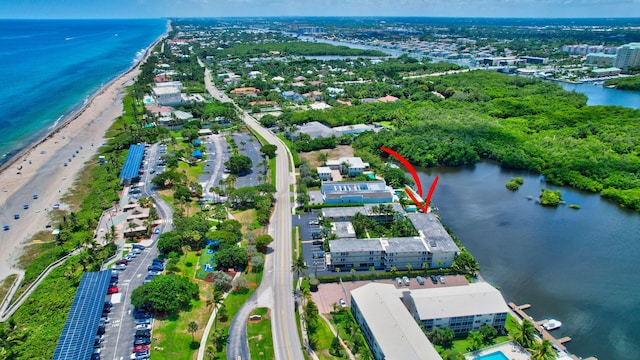 drone / aerial view featuring a beach view and a water view