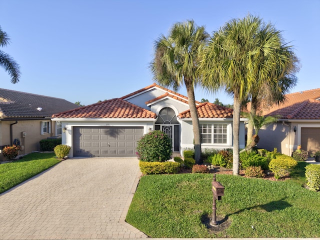 mediterranean / spanish house with a garage and a front lawn