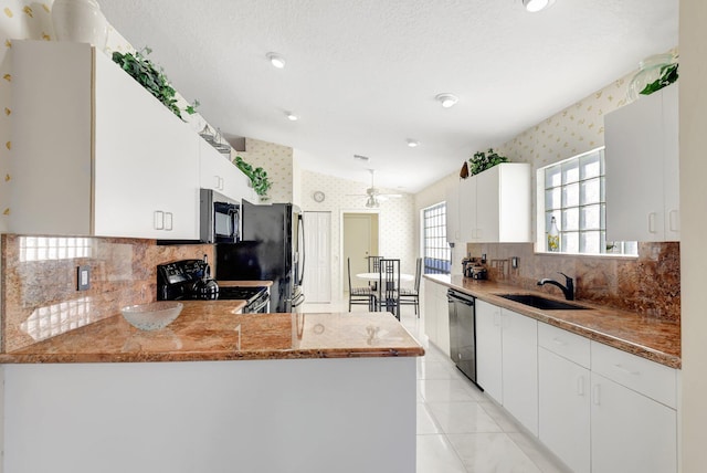 kitchen featuring sink, white cabinetry, vaulted ceiling, appliances with stainless steel finishes, and kitchen peninsula