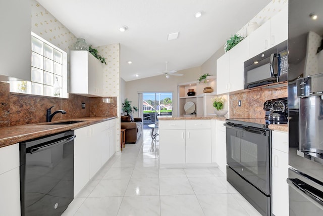 kitchen with lofted ceiling, sink, white cabinetry, black appliances, and kitchen peninsula