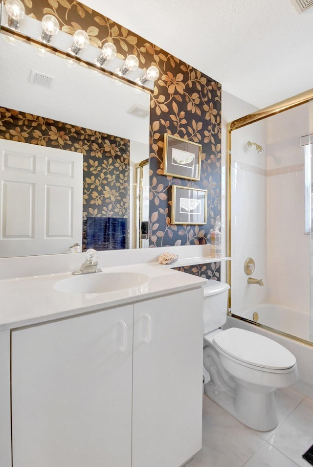 full bathroom featuring bath / shower combo with glass door, vanity, tile patterned floors, and toilet