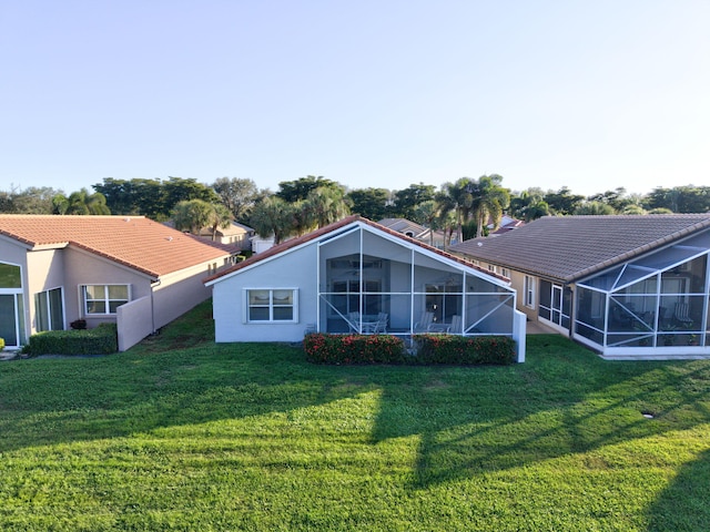 back of property with a lanai and a yard