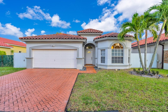 mediterranean / spanish house with a garage and a front yard