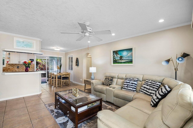 living room featuring light tile patterned floors, ornamental molding, and a textured ceiling