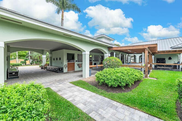 view of property's community featuring a yard, a patio, and an outdoor kitchen