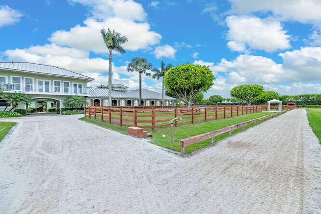 exterior space featuring driveway, a lawn, and fence