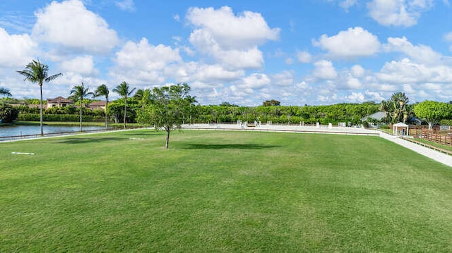 view of property's community featuring a lawn and a water view