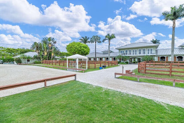 view of home's community with a yard, driveway, a gazebo, and fence