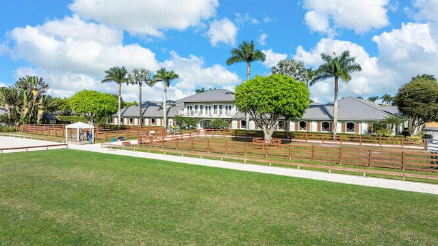 view of property's community with a lawn and fence