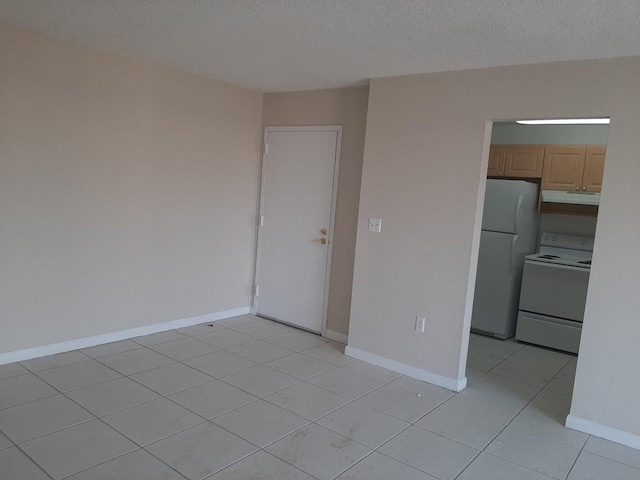 unfurnished room with light tile patterned floors and a textured ceiling