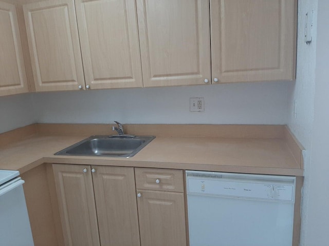 kitchen with sink, light brown cabinetry, and white dishwasher