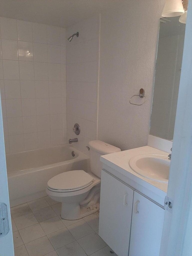 full bathroom featuring tile patterned flooring, vanity, tiled shower / bath combo, and toilet